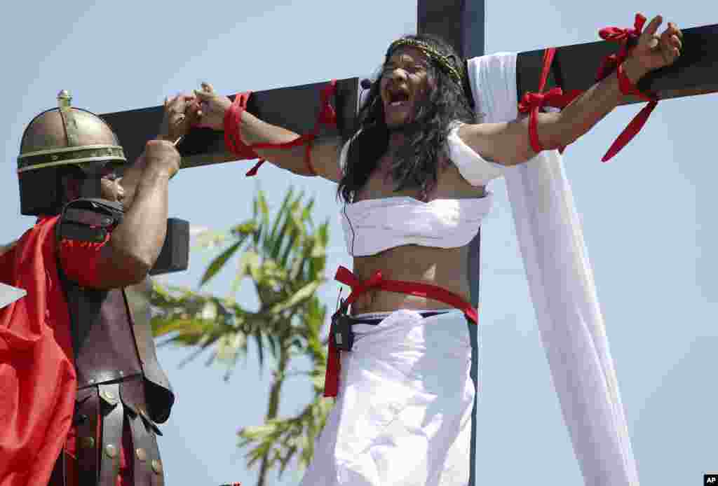 Ruben Enaje, who was portrayed as Jesus Christ 27 times, as a nail is removed from his hand after being crucified during Good Friday rituals in San Pedro Cutud, Philippines, March 29, 2013. 