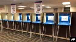 FILE - Voting booths stand ready in downtown Minneapolis for the opening of early voting in Minnesota, Sept. 20, 2018. 