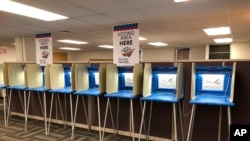 FILE - Voting booths stand ready in downtown Minneapolis for the opening of early voting in Minnesota, Sept. 20, 2018. 