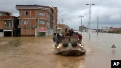 Sebuah kendaraan militer digunakan untuk mengevakuasi warga yang terjebak banjir di kota Aq Qala, provinsi Golestan, Iran. 