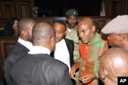 FILE - Biafran separatist leader Nnamdi Kanu, center right, speaks to his lawyers at the Federal High court in Abuja, Nigeria, Jan. 29, 2016. Kanu's current whereabouts are unknown.