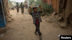 A Somali boy carries a tray of nuts and snacks on top of his head as he walks near a market place in the town of Jawhar in Middle Shabelle region, north of the Somali capital Mogadishu, December 11, 2012.