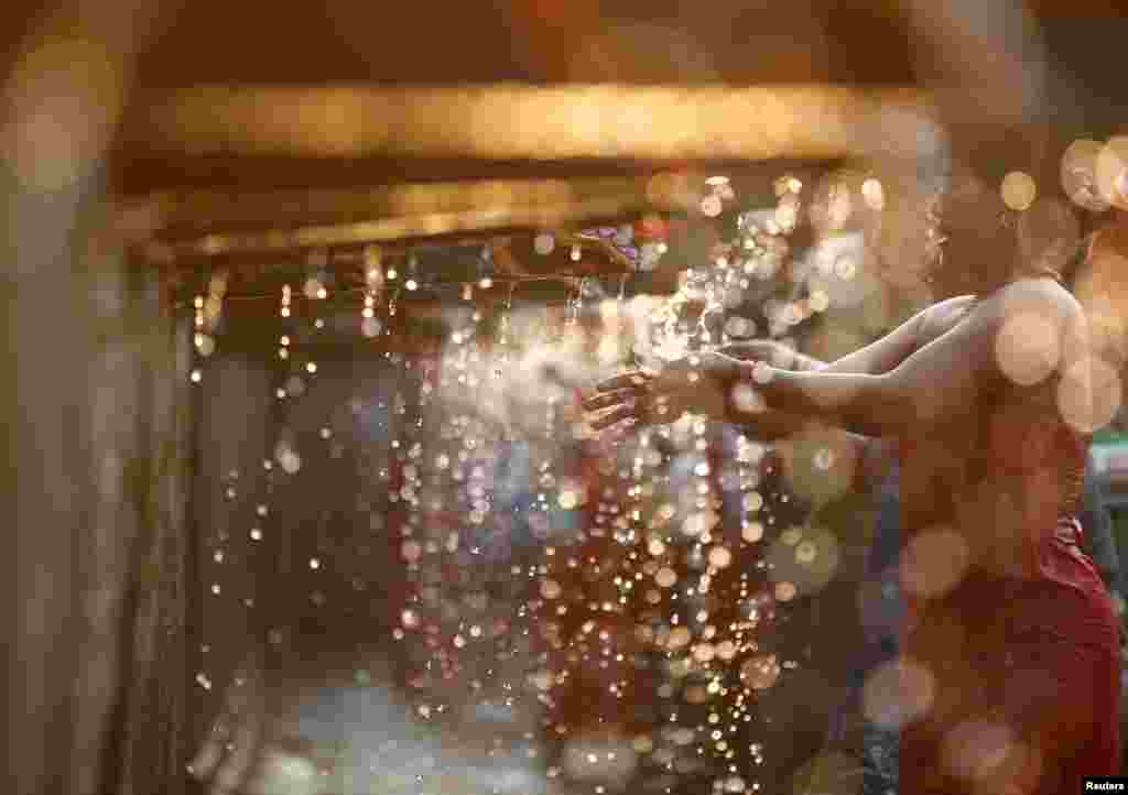 A devotee takes a holy bath at the Balaju Baise Dhara (22 water spouts) during the Baishak Asnan festival in Kathmandu, Nepal.