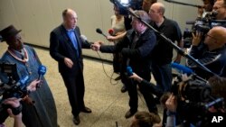 Friends of the Earth campaign leader Geert Ritsema, second left, and plaintiff Eric Dooh, left, give a statement after the ruling in the court case of Nigerian farmers against Shell, in The Hague, Netherlands, January 30, 2013. 