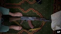 Seorang pejuang Taliban meletakkan senapan AK-47 miliknya saat salat Jumat di sebuah Masjid di Kabul, Afghanistan, Jumat, 10 September 2021. (Foto: AP//Felipe Dana)