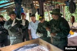 Venezuela's Defense Minister Vladimir Padrino (front L) speaks during a military operation to destroy a clandestine drug laboratory, near of the border with Colombia, in the state of Zulia, Dec. 6, 2014.