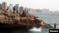 Youths jump into the sea to cool off on a hot day in the Egyptian coastal city of Alexandria May 24, 2013.