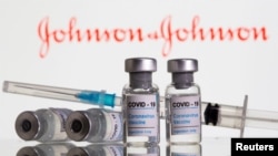 Botol berlabel "Vaksin Coronavirus COVID-19" dan jarum suntik terlihat di depan logo Johnson&Johnson yang ditampilkan dalam ilustrasi, 9 Februari 2021. (Foto: REUTERS/Dado Ruvic)
