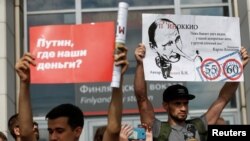Demonstran membawa poster ketika memprotes rencana reformasi pensiun Rusia di St. Petersburg, Rusia, 9 September 2018. 
