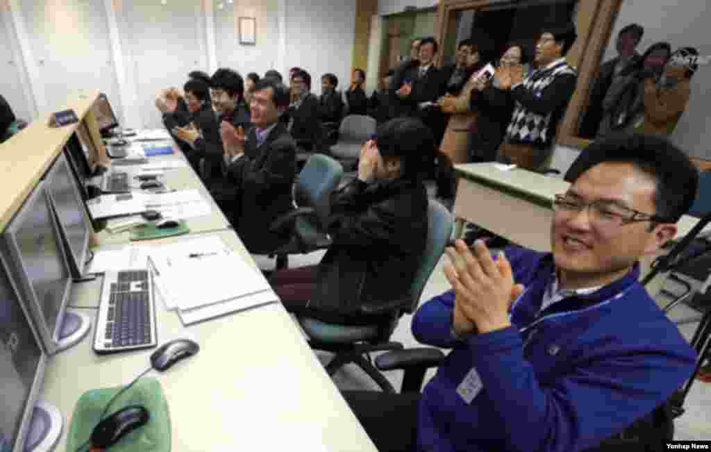 31일 나로과학위성과 교신에 성공하고 나서 환호하는 한국 카이스트 인공위성센터 관계자들.