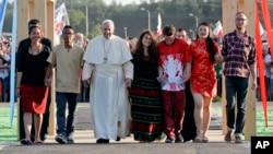 Pope Francis, accompanied by youths, passes through the Door of Mercy ahead of a prayer vigil on the occasion of the World Youth Days, in Campus Misericordiae in Brzegi, near Krakow, Poland, July 30, 2016.