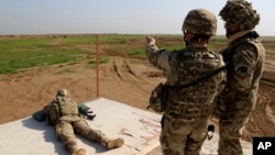 Ảnh tư liệu - Những huấn luyện viên người Mỹ và Tây Ban Nha sử dụng đạn thật trong các cuộc diễn tập tại khu căn cứ quân sự Basmaya, cách thủ đô Baghdad, Iraq, 40km về phía đông nam. 