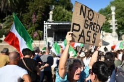 FILE - Protesters take part in a demonstration against the introduction of a mandatory "green pass" to limit the spread of COVID-19, at the Piazza del Popolo, in central Rome, Italy, Aug. 7, 2021.
