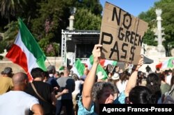 FILE - Protesters take part in a demonstration against the introduction of a mandatory "green pass" to limit the spread of COVID-19, at the Piazza del Popolo, in central Rome, Italy, Aug. 7, 2021.