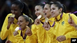 Members of the Brazil women's volleyball team show off their gold medals following a 3-1 win over the United States during the women's gold medal volleyball match at the 2012 Summer Olympics, Saturday, Aug. 11, 2012, in London. 