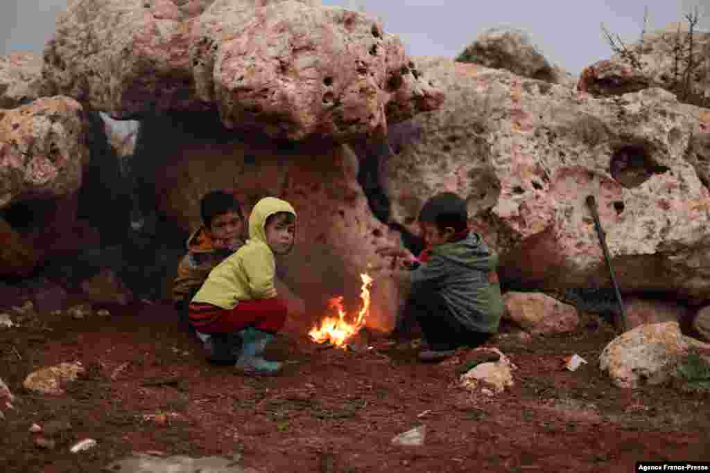 Children gather in front of a camp fire, in the Bardaqli camp for displaced people in the town of Dana in Syria&#39;s northwestern Idlib province, Nov. 20, 2021, as winter approaches on the International Day of Children&#39;s Rights.