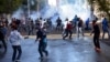 FILE - In this Oct. 7, 2014, photo, Turkish riot police use water cannons and tear gas to disperse people protesting against Turkey's policy in Syria, in Diyarbakir, Turkey. 