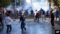 FILE - In this Oct. 7, 2014, photo, Turkish riot police use water cannons and tear gas to disperse people protesting against Turkey's policy in Syria, in Diyarbakir, Turkey. 