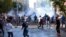 FILE - In this Oct. 7, 2014, photo, Turkish riot police use water cannons and tear gas to disperse people protesting against Turkey's policy in Syria, in Diyarbakir, Turkey. 