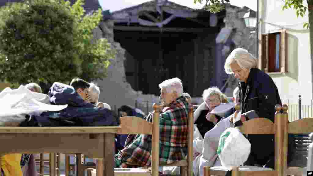 Des résidents sont assis en plein air à Cumuli, le 24 août 2016.