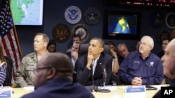 President Barack Obama, center, attends a briefing with Federal Emergency Management Agency administrator Craig Fugate, right, at the National Response Coordination Center at FEMA Headquarters in Washington, on Sunday, Oct. 28, 2012.