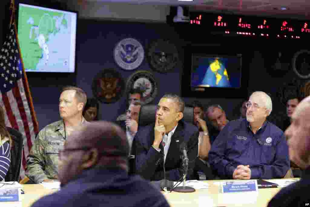 President Barack Obama, center, attends a briefing with Federal Emergency Management Agency administrator Craig Fugate, right, at the National Response Coordination Center at FEMA Headquarters in Washington, on Sunday, Oct. 28, 2012.