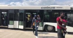 Haitian migrants exit a bus