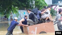 Warga Jakarta mengungsi dari banjir dengan menggunakan gerobak, 13/1/2014 (VOA/Iris Gera)