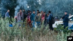 Migran gelap terlihat sedang menunggu di perlintasan kereta api antara Hungaria dan Serbia dekat Roszke, 180 kilometer selatan Budapest, Hungaria (25/8). 