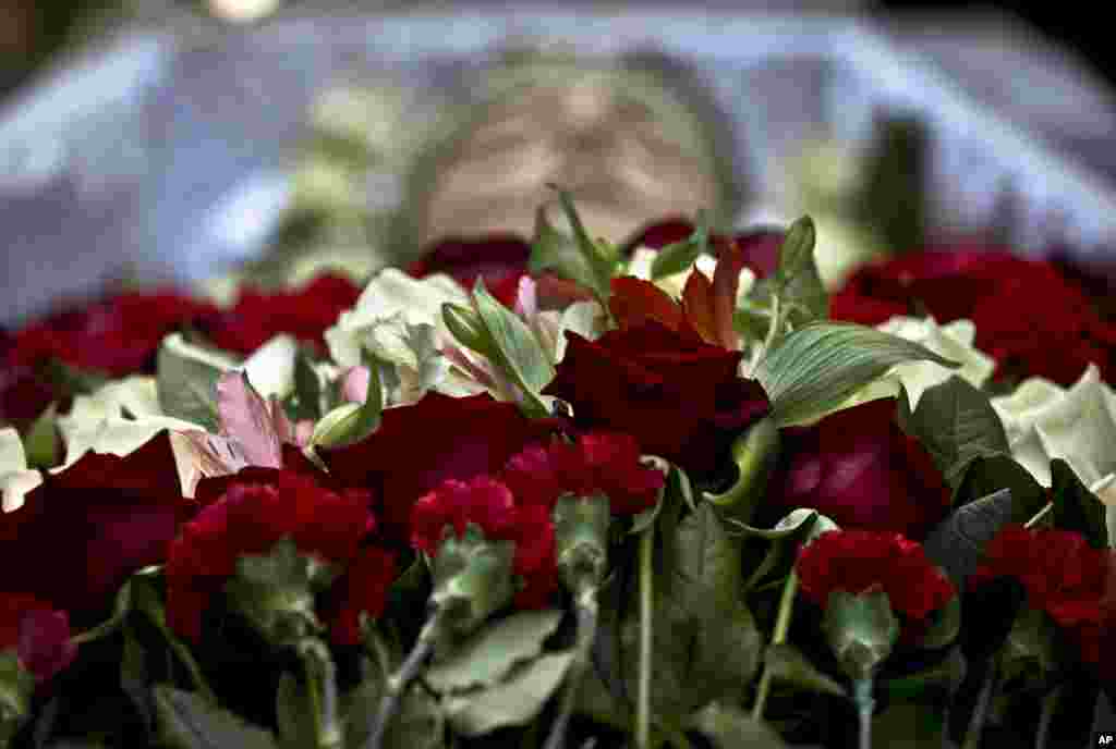 Flowers cover the coffin of 17 year-old Vadim Papura during a religious service outside the apartment block where he lived, in Odessa, Ukraine, Tuesday, May 6, 2014. Papura died after jumping out of the burning trade union building in an attempt to escape Friday&#39;s fire that killed most of the 40 people that died after riots erupted last Friday.(AP Photo/Vadim Ghirda)