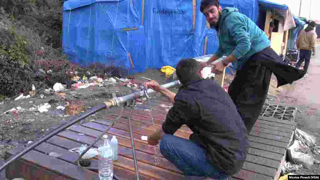 Migrants are washing their hands in the "Jungle" in Calais, France (Nicolas Pinault/VOA)