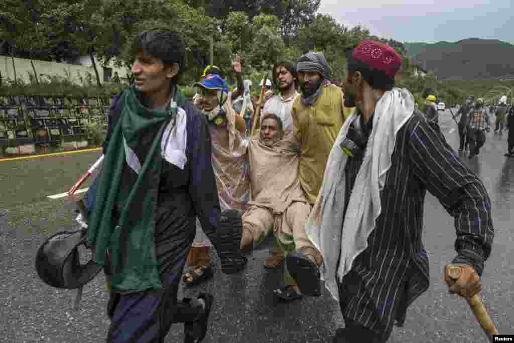 Demonstrators help an injured comrade, Islamabad, Sept. 1, 2014.