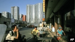 Uighurs rest outside a Xinjiang restaurant in front of commercial buildings in Beijing, (File)