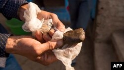 Un agriculteur expose un morceau de résine de cannabis près de la ville de Ketama dans la région nord du Rif au Maroc, le 13 septembre 2017.
