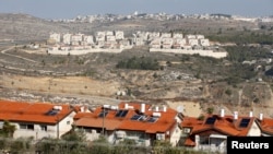 Houses in the Israeli settlement of Givat Zeev are seen from the Israeli settlement of Givon Ha'hadasha, at bottom, in the occupied West Bank, Dec. 29, 2016.