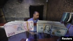 Banknotes of U.S. dollars and Turkish lira are seen in a currency exchange shop in the city of Azaz, Syria, Aug.18, 2018. 