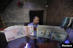 Banknotes of U.S. dollars and Turkish lira are seen in a currency exchange shop in the city of Azaz, Syria, Aug.18, 2018.