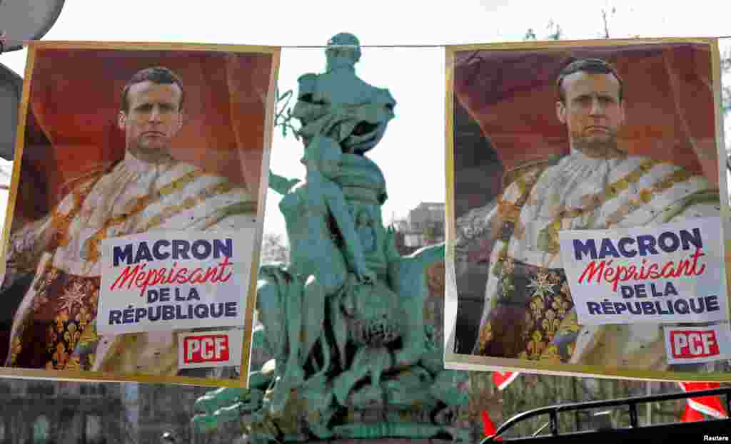 Posters with drawings of French President Emmanuel Macron wearing the coronation clothing of King Louis XVI are shown during a demonstration by labor unions against the government&#39;s reforms, in Paris.
