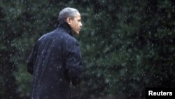 Tổng thống Obama đi bộ tới Phòng Bầu Dục của Tòa Bạch Ốc trong trời mưa hôm thứ hai 29/10/2012. 