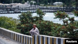 FILE - A man sits on a boundary wall near the Indus river in Gilgit.