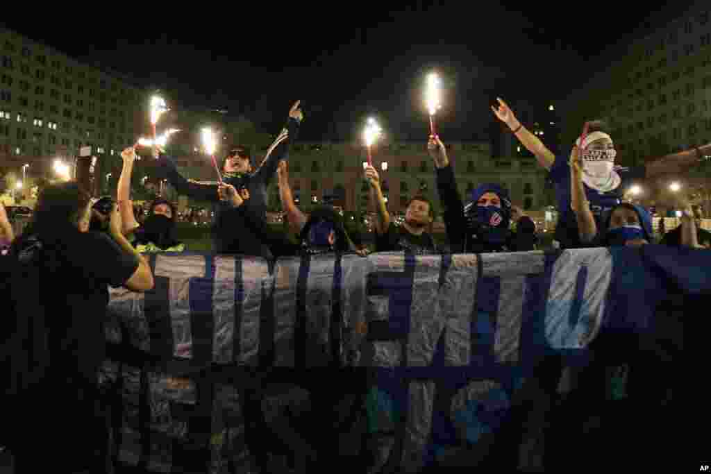 Some protesters, hold torches in front of La Moneda palace, during a march ahead of International Women&#39;s Day in Santiago, Chile, March 6, 2015.