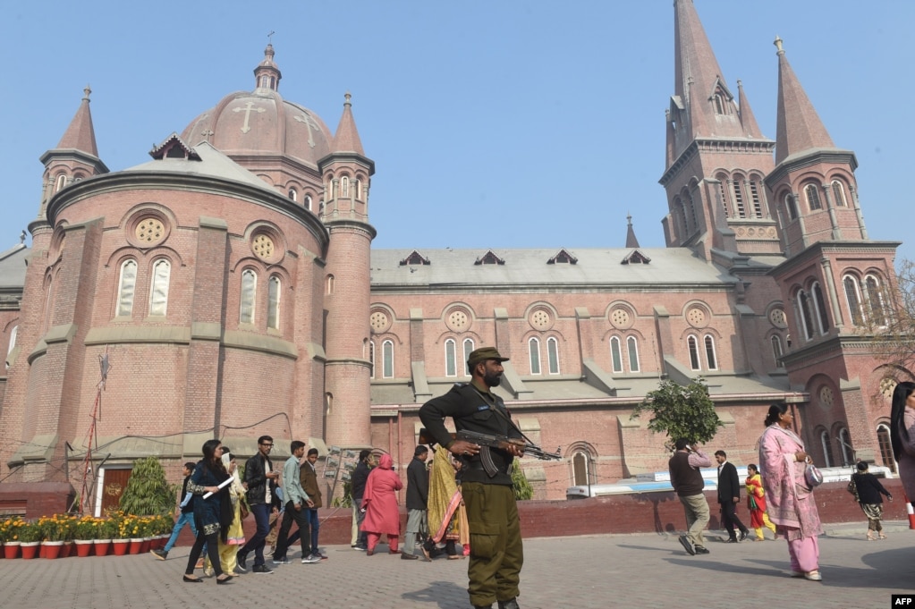 Pakistani police stand guard at a church during the Christmas Day mass in Lahore, Dec. 25, 2017. 