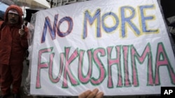 A demonstrator holds a "No more Fukushima" sign during a rally, protesting against restarting the Ohi nuclear power plant's reactors in front of the prime minister's official residence in Tokyo, Saturday, June 16, 2012.