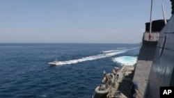 美国海军公布的照片显示，伊朗共和国卫队的舰艇在科威特附近的波斯湾海域驶近美国军舰。(2020年4月15日)