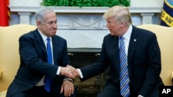 Le président Donald Trump échange une poignée de mains avec le Premier ministre israélien Benjamin Netanyahu dans le bureau ovale de la Maison Blanche, le 5 mars 2018.