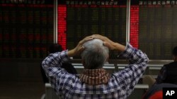 중국 베이징의 투자자가 이달초 증권거래 현황표를 보며 머리를 감싸고 있다. 