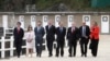 Participants of a G-7 ministerial meeting walk to have a group photo taken on the second day of their talks, in Dinard, France, April 6, 2019.