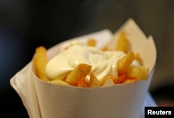 A large cone of fries with mayonnaise sauce is pictured at the Maison Antoine frites stand in Brussels, Belgium, Dec. 4, 2014.