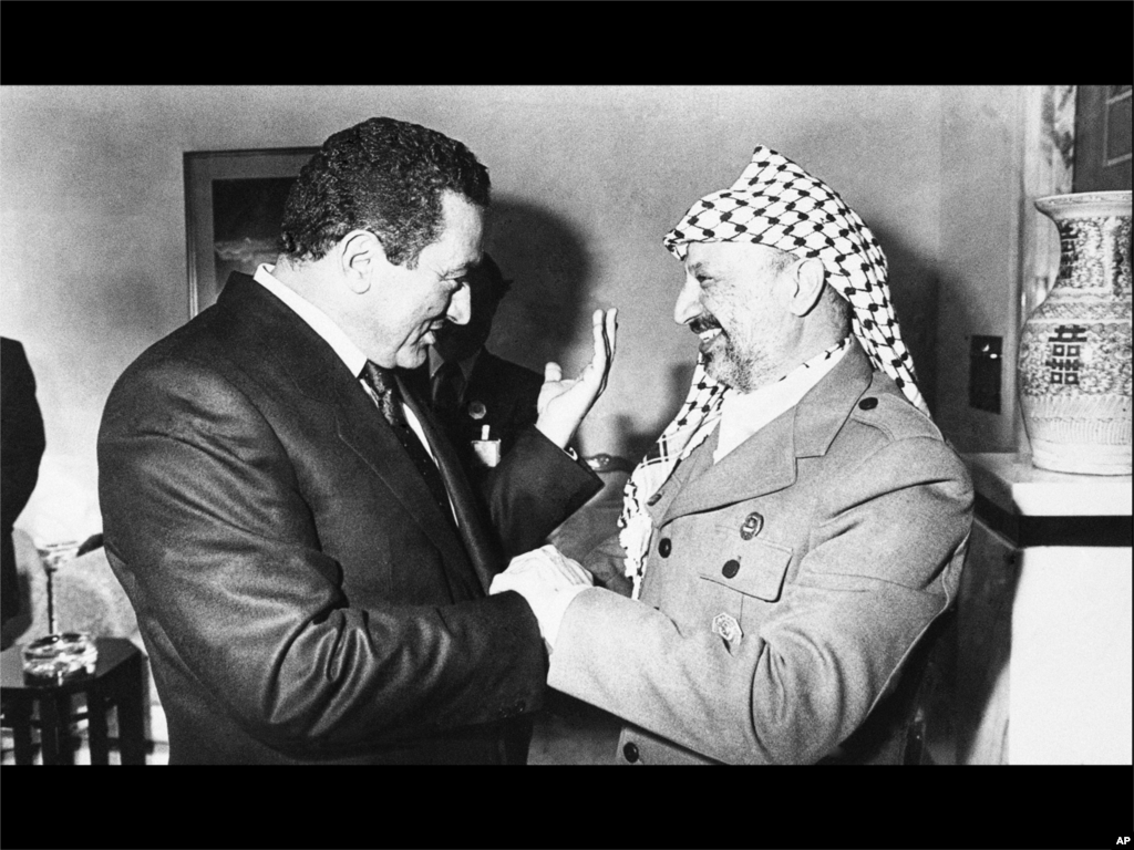 (美联社) 1987年一月二十七号，埃及总统穆巴拉克，左，与巴解组织领袖阿拉法特在科威特举行的第五届伊斯兰峰会场外会晤