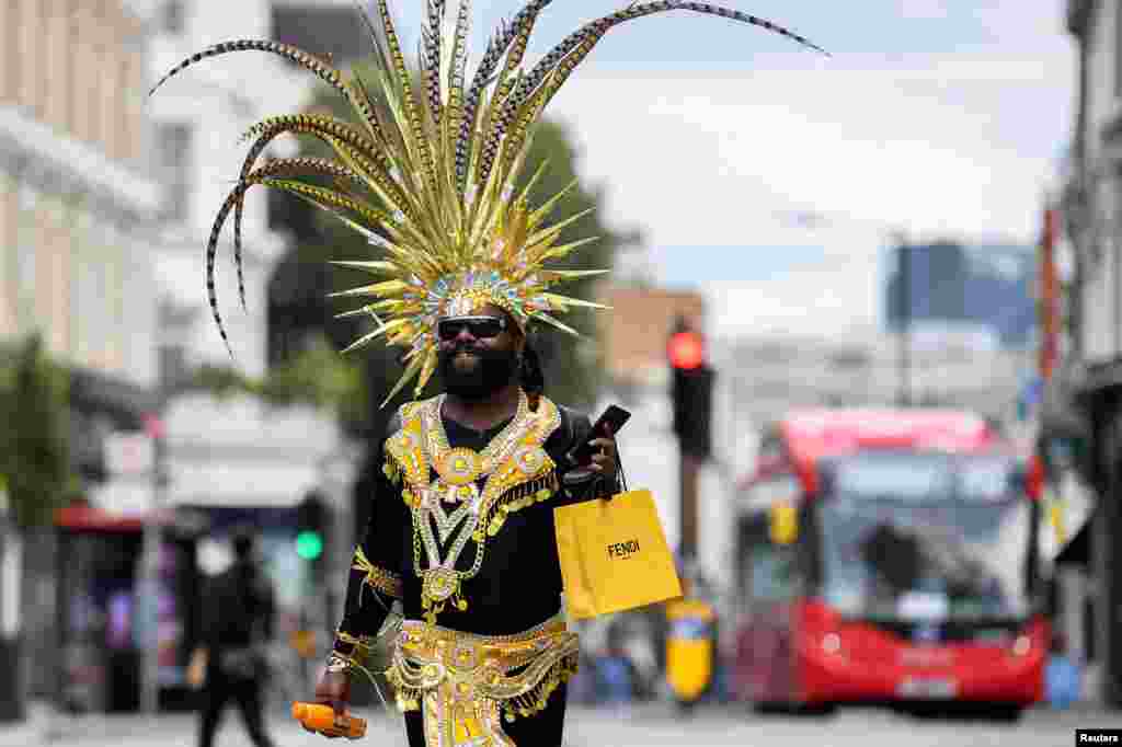 A festival goer dances in a street after the Notting Hill Carnival festivities were cancelled amid the coronavirus disease (COVID-19) outbreak, in London.